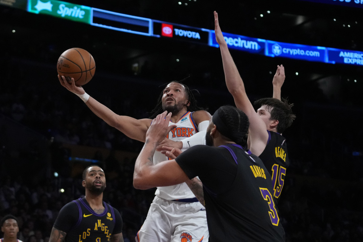 Dec 18, 2023; Los Angeles, California, USA; New York Knicks guard Immanuel Quickley (5) shoots the ball against Los Angeles Lakers guard D'Angelo Russell (1), forward Anthony Davis (3) and guard Austin Reaves (15) in the first half at Crypto.com Arena.
